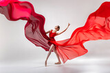 Ballerina in red leotard dancing in white studio room with red clothes waving around
