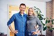 © baranq - Portrait of middle aged couple home owners stainding indoors