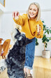 © baranq - Smiling woman playing with dog feeding with banana