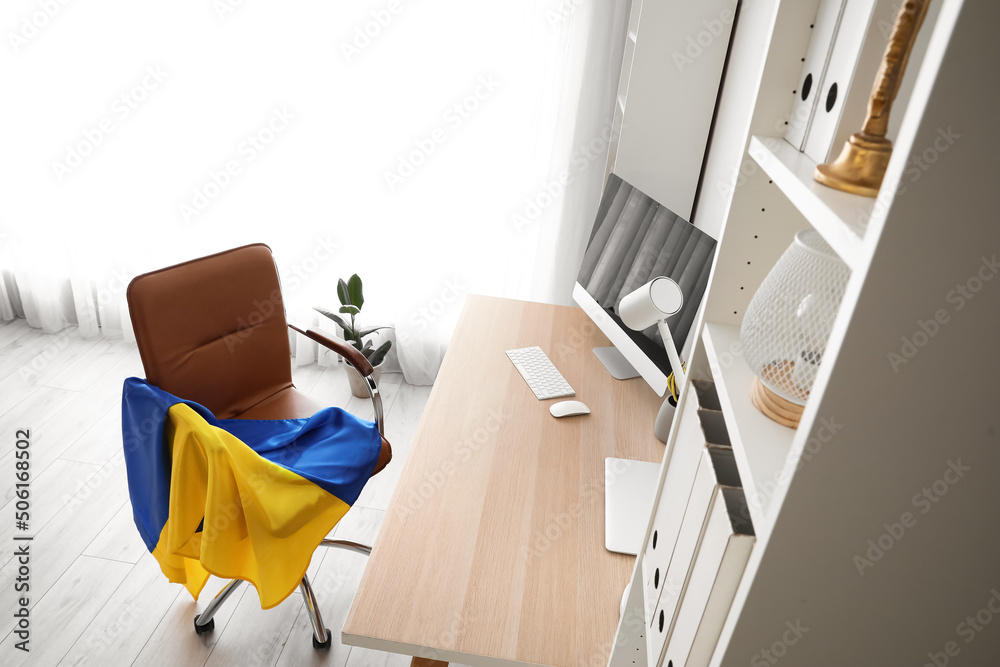 Flag of Ukraine on chair in modern office