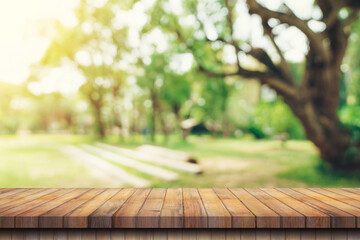 Wall Mural - Empty wooden table top and Abstract blurred light bokeh and blur background of garden trees in sunlight. product display template with copy space.