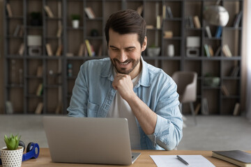 Wall Mural - when job is pleasure. happy millennial businessman sit at home office desk corresponding with custom