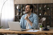 © fizkes - Got it. Glad male entrepreneur sit at desk look at distance above pc screen happy to answer important question. Smiling young man remote student feel satisfied after understanding difficult subject