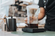 © sarayutsridee - Barista making coffee by pour over in coffee shop.. Close up of hands barista to making a drip coffee. Coffee shop concept