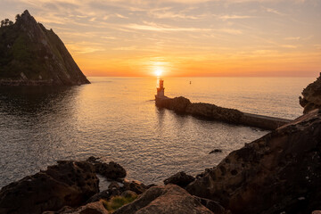 Wall Mural - Orange sunset at the Lighthouse of the bay of Pasaia in the town of San Juan. Gipuzkoa. Basque Country