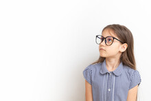 A 7-year-old Girl With Glasses With Sad Faces. Children's Education, Learning Concept With Copy Space
