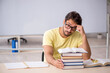 © Elnur - Young male student preparing for exams in the classroom