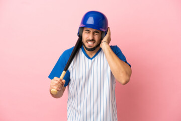 Wall Mural - Baseball player with helmet and bat isolated on pink background frustrated and covering ears