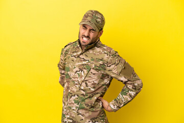 Wall Mural - Military man isolated on yellow background suffering from backache for having made an effort