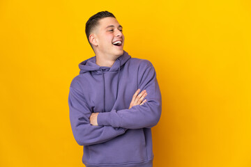 Young caucasian man isolated on yellow background happy and smiling