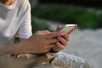 Poster - A close up of a male enjoying using a smartphone in an outdoor place. Business and technology concepts.