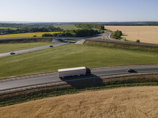 Wall Mural - Truck with Cargo Semi Trailer Moving on Summer Road. Aerial Top View. White vehicle