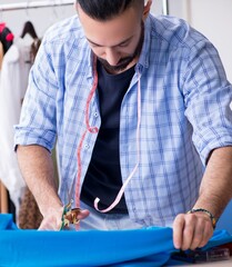 Wall Mural - Male tailor working in the workshop on new designs