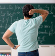 © Elnur - Young male student mathematician in front of chalkboard