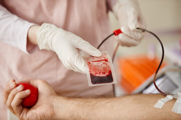 Poster - Close up of nurse adjusting blood bag of male donor at blood donation center or hospital, copy space