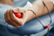 canvas print picture Close up of young man donating blood and holding red ball in hand, copy space