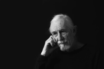 Wall Mural - Low key studio black and white portrait of sad beautiful gray hair old man. 