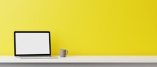 Blank Computer Laptop Screen And Various Items On Desktop Workspace In Yellow Wall Home Office Room. 3D Renering Illustration.