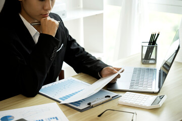 Sticker - businesswoman in a suit sits on her desk in a modern office