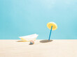 Sunshade, parasol made of lemon and blue drinking straw. Beach ball and boat in the sand. Minimal summer vacation composition.