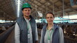 © stockbusters - Portrait livestock team posing together modern cowshed at dairy farm facility