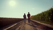 © stockbusters - Agronomists walking ground road together. Farmers silhouettes inspecting harvest