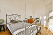 © ADDICTIVE STOCK - Bedroom interior with metal frame bed and commode