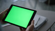 © stockbusters - Entrepreneur hands holding tablet looking screen chroma key in workplace cafe.