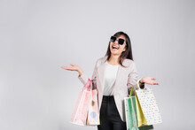 Woman With Glasses Confident Shopper Smiling Holding Online Shopping Bags Colorful Multicolor, Portrait Excited Happy Asian Young Female Person Studio Shot Isolated On White Background, Fashion Sale
