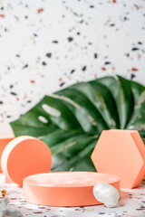 Poster - peach geometric pedestal on terrazzo background with summer sunlight and green monstera leaf