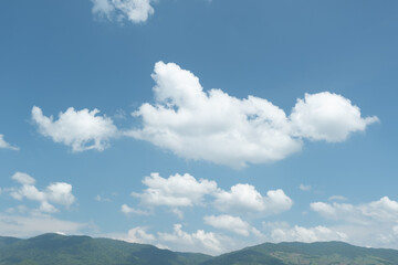Wall Mural - the white clouds have a strange shape and moutain.the sky and the open space have mountains below.