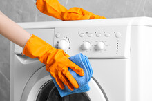 Woman Cleaning Washing Machine With Rag Indoors, Closeup