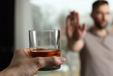 Fototapeta Łazienka - Man refusing to drink whiskey indoors, closeup. Alcohol addiction treatment