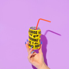 Wall Mural - Summer creative layout with woman hand with long nails holding soda can wrapped in warning packing tape  on pastel purple background. 80s or 90s retro fashion aesthetic drink  concept. Pop art idea.