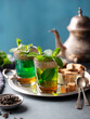 Moroccan mint tea in traditional glasses on silver tray. Blue background. Copy space.