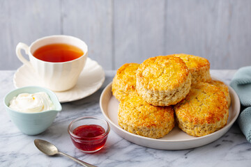 Wall Mural - Scones with jam, clotted cream and cup of tea. Grey background. Close up.