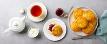 Scones, Tea Cakes With Jam, Clotted Cream With Tea. Traditional British Teatime. Grey Background. Top View.