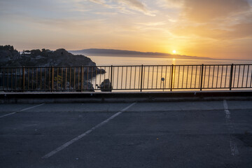 Wall Mural - an asphalt parking lot for cars by the sea at sunrise