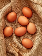 Wall Mural - Fresh farm brown eggs on burlap