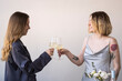 © Westend61 - Happy female friends toasting wineglasses in front of wall