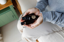 Woman Holding Essential Oil Bottles At Home
