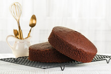 Just Baked Plain Chocolate Sponge Cake On The Cooking Iron Grid, White Table. Fluffy, Moist And Rich Chiffon Cake, Homemade. Cooking Utensils.