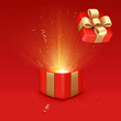 Open red gift box with golden ribbon and glow.