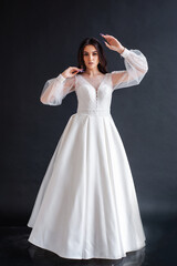 Wall Mural - Beauty Portrait of bride wearing in wedding dress with voluminous skirt, studio photo. Young attractive bride. Smiling beautiful young bride