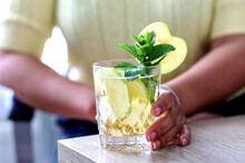 Woman Holding A Glass Of Cocktail Garnish With Sliced Apple And Mints Leaves. Homemade Cold Summer Drinking Refreshing At Home