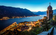 Panoramic Evening View Of The Church, The Old Town And The Bay Of Kotor From Above. The Bay Of Kotor Is The Beautiful Place On The Adriatic Sea. Kotor, Montenegro.