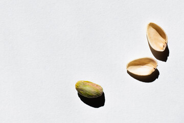 Wall Mural - top view of cracked green and salty pistachio on white background