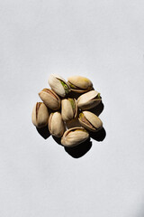 Canvas Print - top view of pile with cracked green and salty pistachios on white background