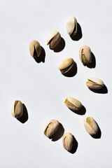 Sticker - top view of cracked green and salty pistachios on white background