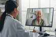 © Nattakorn - Female Asian doctor making video call with Asian senior woman grey hair 80-90s, telemedicine telehealth concept